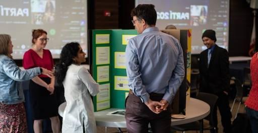 2 people talking in front of a presentation